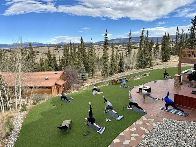 Men practicing yoga outdoors at Valiant Living, seen from above.
