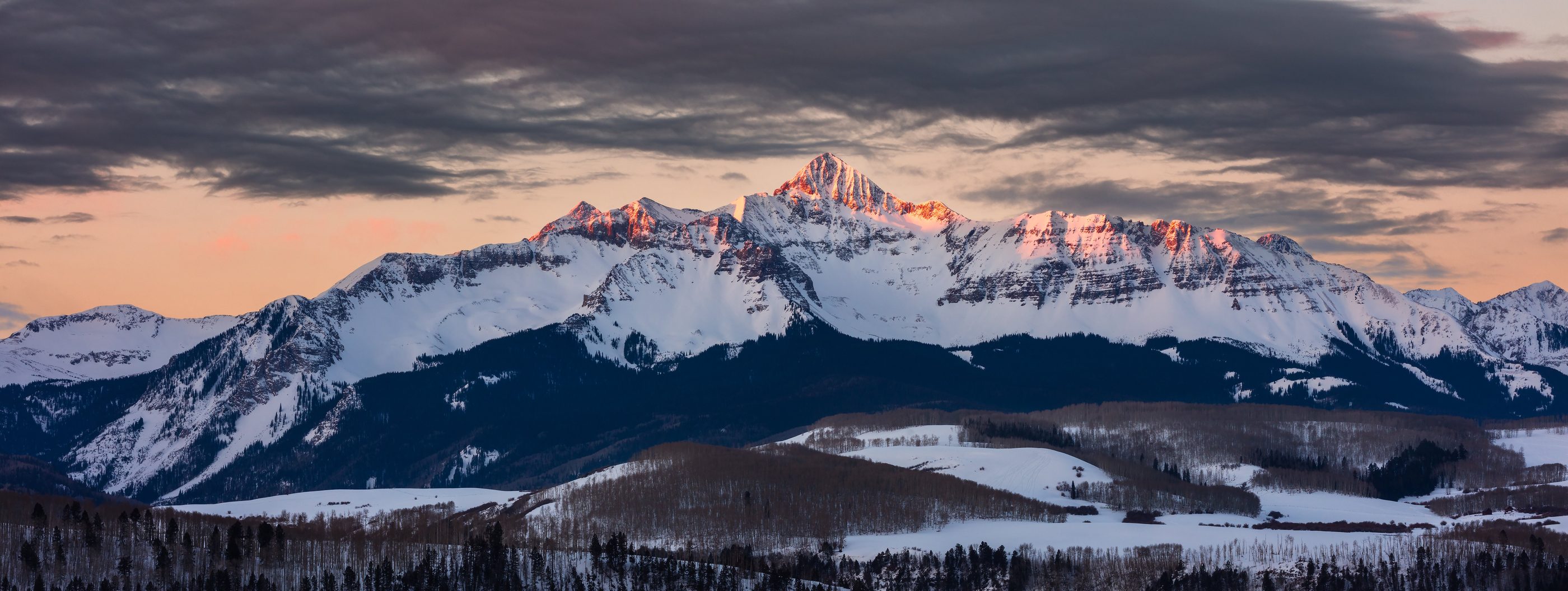 Alpenglow on a snow capped Colorado peak at dusk