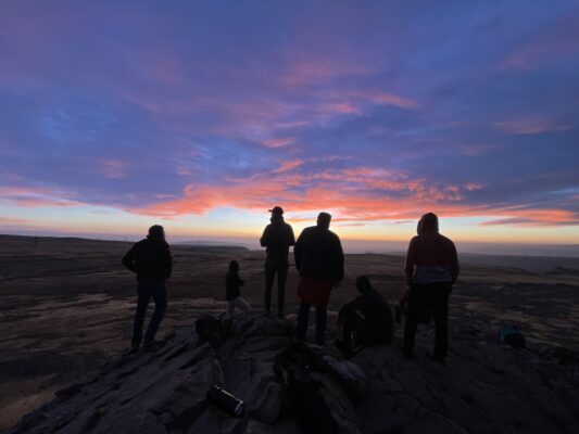 Valiant men watching the sunrise from a Colorado summit on an outdoor experiential therapy day